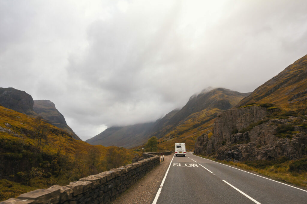 motorhome driving on road though scottish countryside mountains
